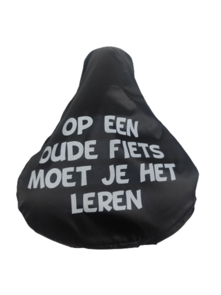 Zadelovertrek met tekst '' op een oude fiets moet je het leren '' - Zwart / Wit - PVC - Rekbaar - Grappige Zadelhoes - Fietshoes - Foute tekst 